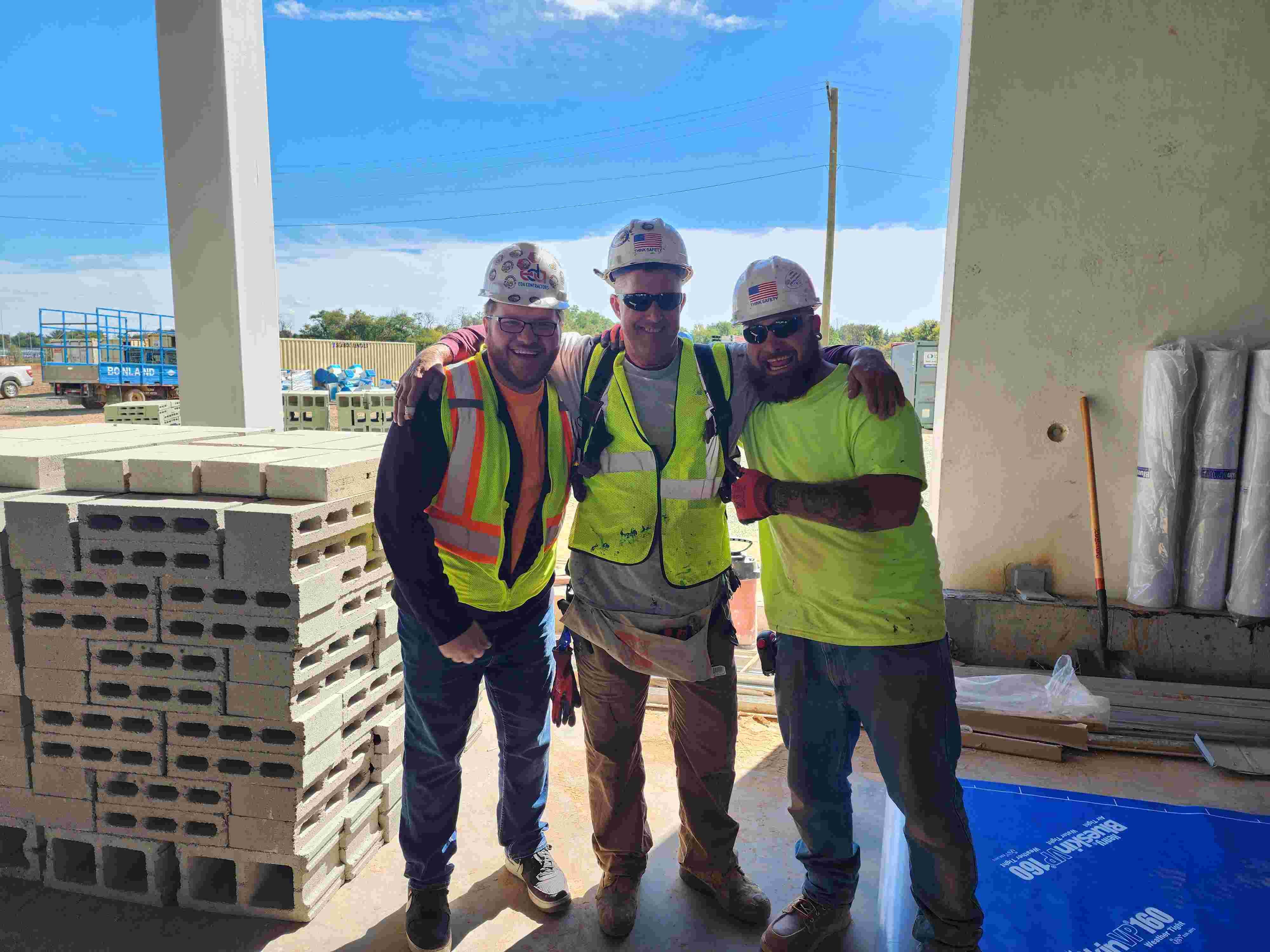 Three construction workers on jobsite looking at camera