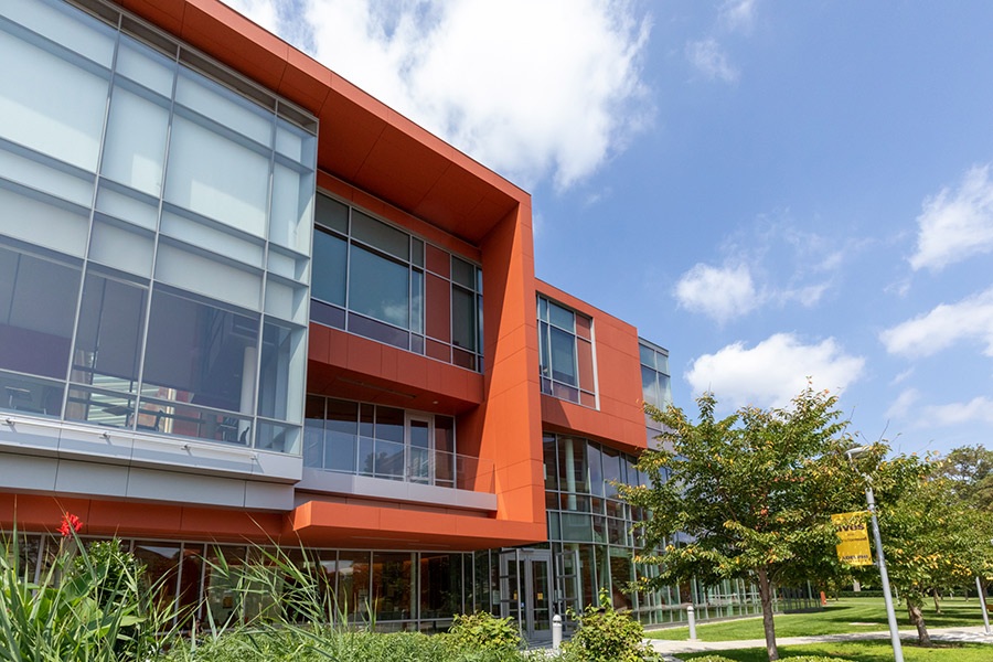 Image of the front of the new building at Adelphi University Nexus. Orange paneling with large glass windows