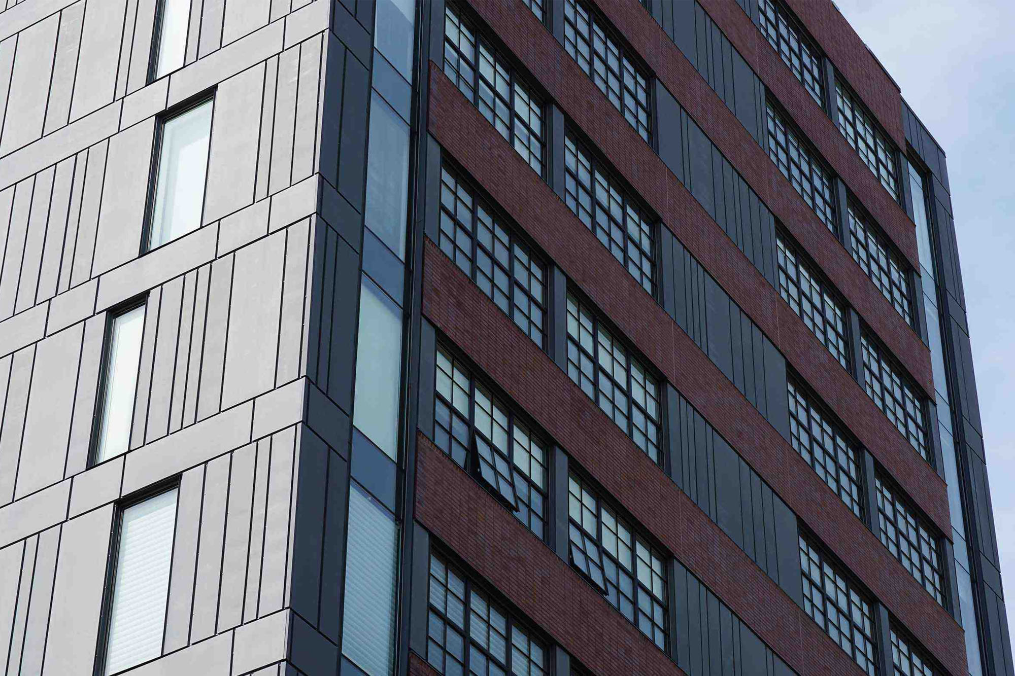 image at corner of 108 Arch Street. Brick with windows on right side and metal panels on left.